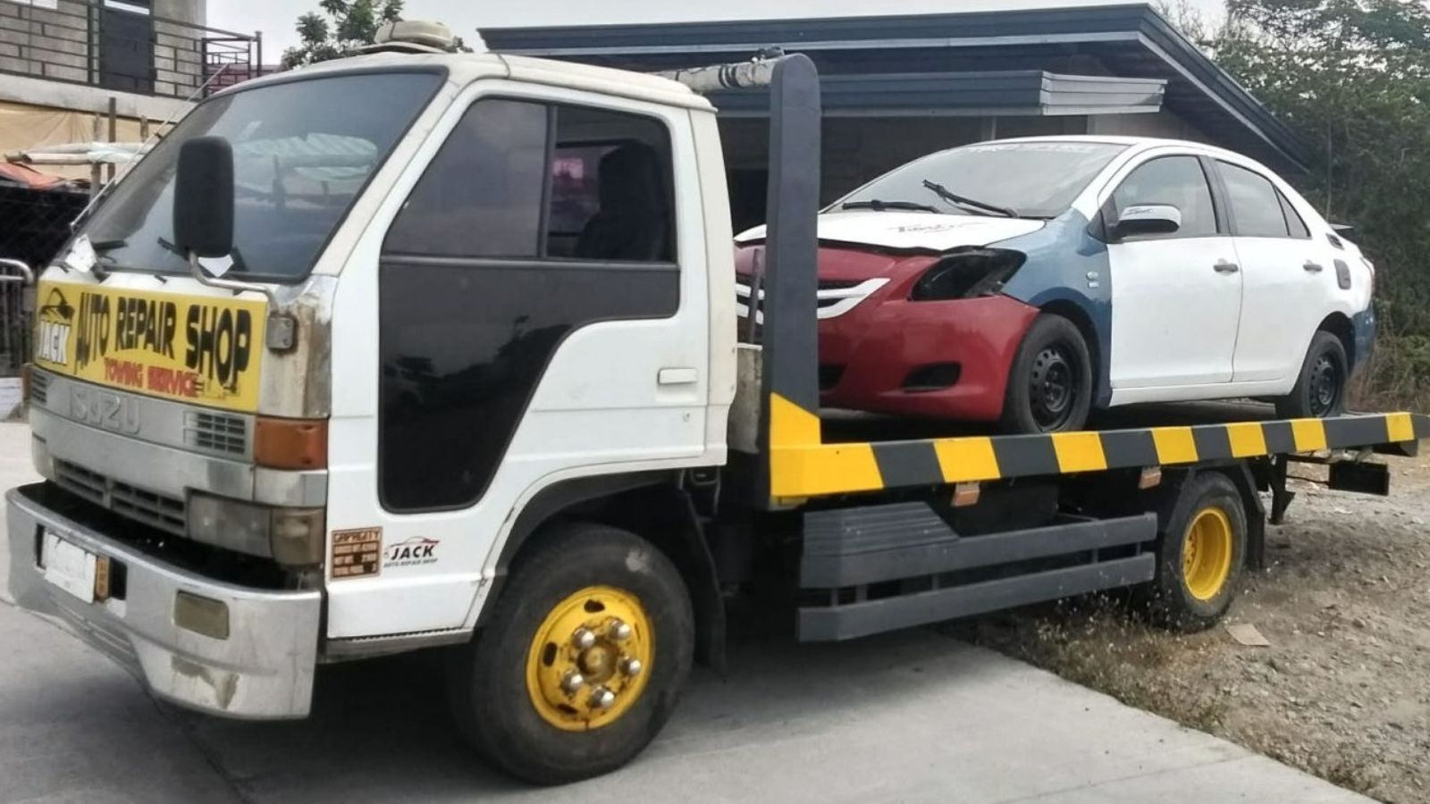 Repossession team documenting vehicle recovery with clipboard and tow truck